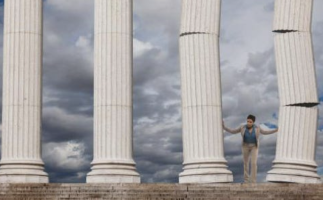 Man standing in front of four pillars