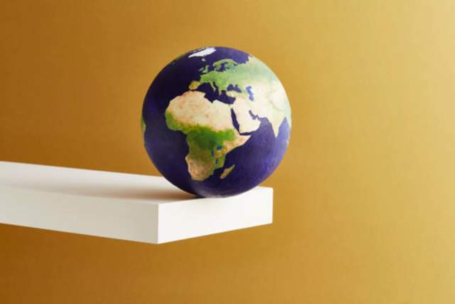 A globe sitting on the end of a plank