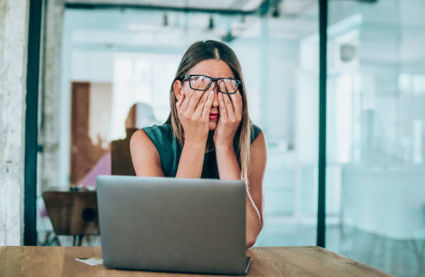 photo of a woman stressed in front of a laptop