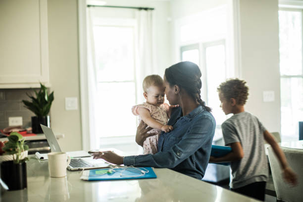 A mother working at a desk with her kids
