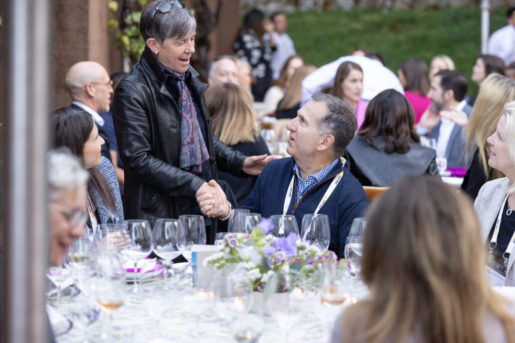 People shake hands at a One Mind event